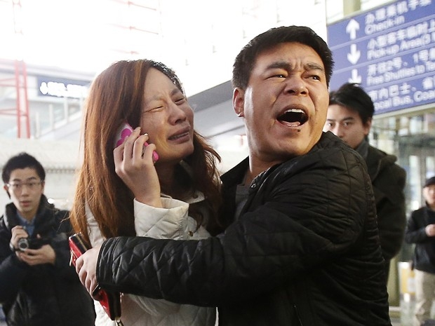 Parente de passageiro do voo MH370 da Malaysia Airlines chora enquanto fala no celular no Aeroporto Internacional de Pequim, China, neste sbado (8). O voo que ia de Kuala Lumpur a Pequim, na China, est desaparecido. Aeronave levava 239 pessoas a bo