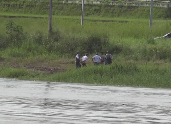 rapaz preso saindo do rio conduzido por policiais